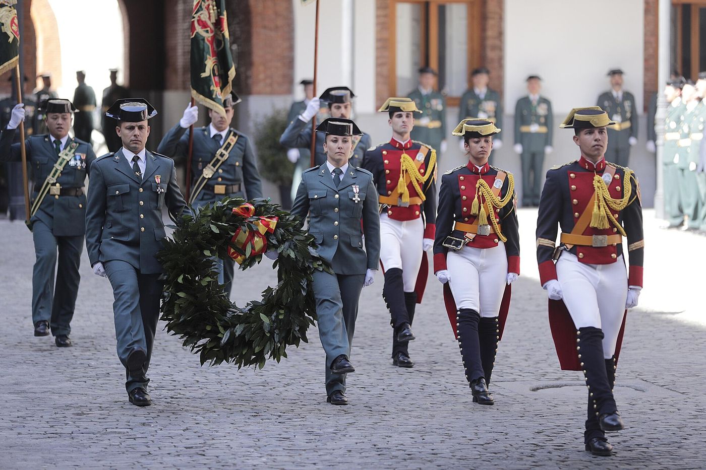 Guardias civiles de gala llevan una corona de laurel en el homenaje a los caídos