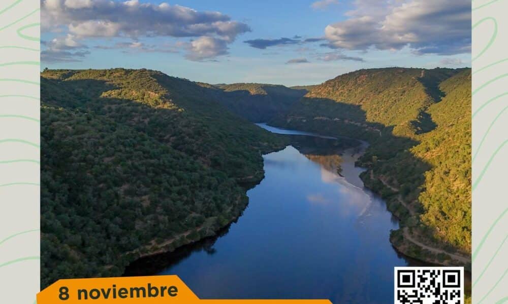Vista panorámica de un embalse alargado entre laderas boscosas, con cielo parcialmente nublado y un rótulo que dice 8 noviembre.