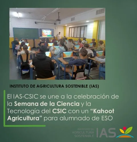 Aula con alumnado de espaldas sentado ante portátiles en pupitres, con una pantalla y una pizarra al frente.